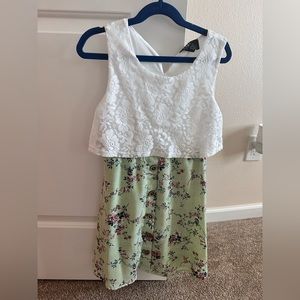 Sleeveless dress. White lace top, green floral bottom.